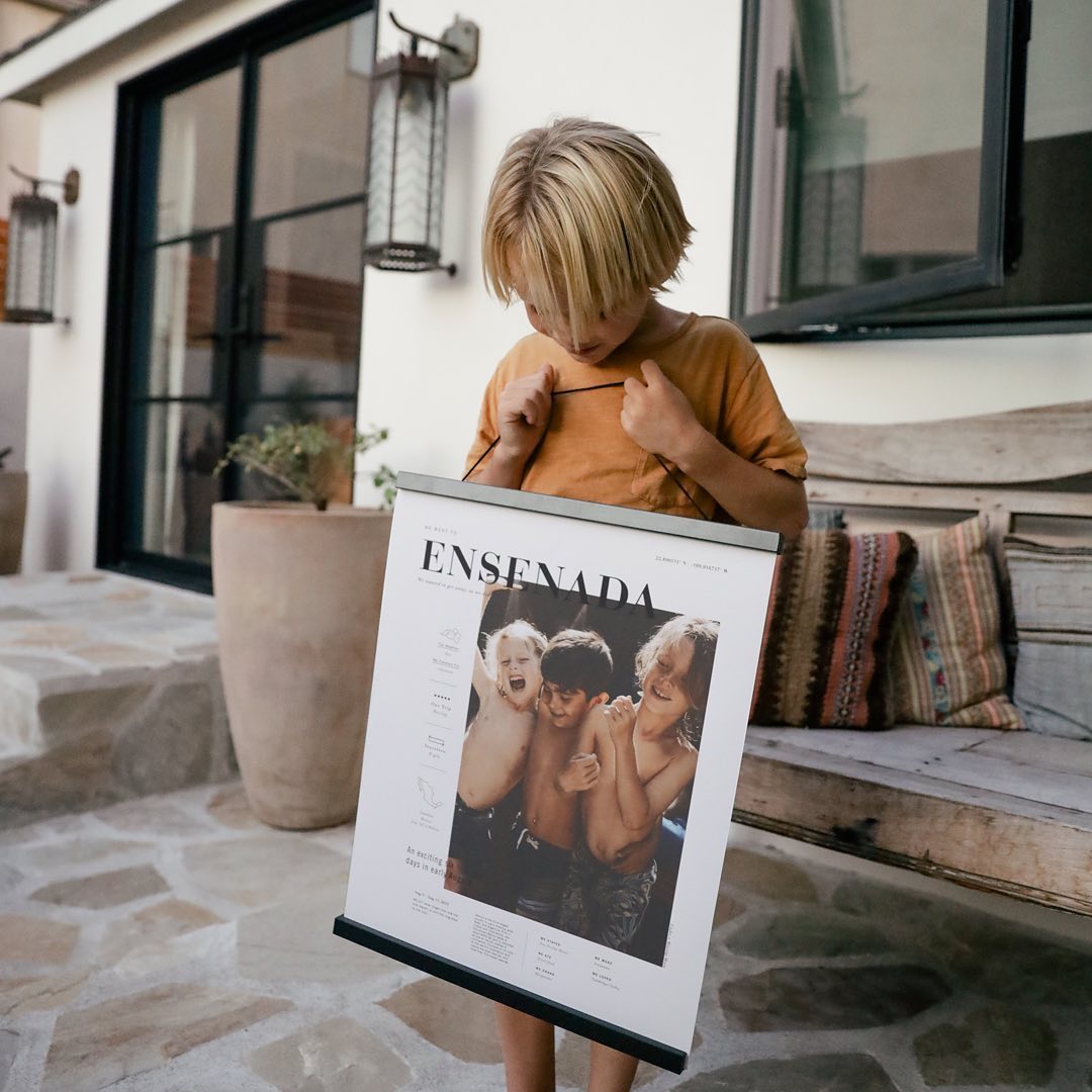 Boy holding an art piece in a magnetic hanger frame. 